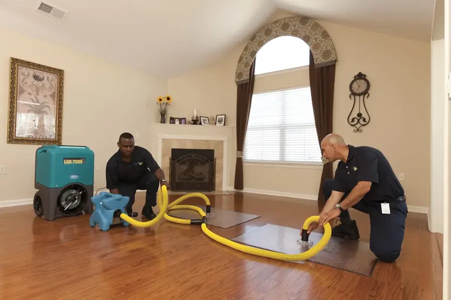Technicians extracting water from a soaked floor in a Bronx, NY apartment